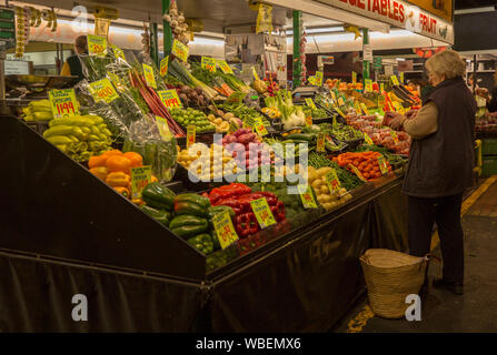 Frau einkaufen bei Gemüse an australischen Marktstand mit bunten Anzeige von Karotten, Paprikaschoten, Brokkoli und andere gesunde und nahrhafte Lebensmittel Stockfoto