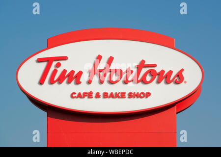 Signage zeigt einen Drive Thru Zweig der Tim Hortons Cafe und Bäckerei auf Bury New Road in Manchester, UK. Stockfoto