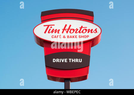 Signage zeigt einen Drive Thru Zweig der Tim Hortons Cafe und Bäckerei auf Bury New Road in Manchester, UK. Stockfoto