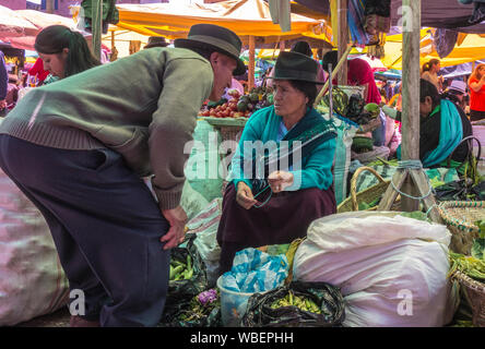 Cuenca, Ecuador - Dec 30, 2012: Mann spricht mit widerstrebenden Frau im Markt Stockfoto