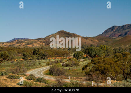 Straße windet sich durch Flinders Ranges National Park mit schroffen felsigen reicht bis in den blauen Himmel, South Australia Stockfoto