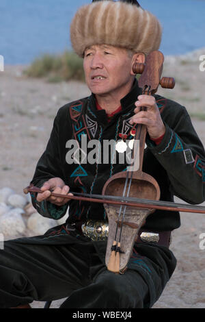 Issyk Kul, Kirgisistan - Mai 28, 2017 - Musiker spielt traditionelle Komuz bundlosen Saiteninstrument Stockfoto