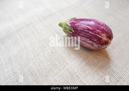 Eine Auberginen aus dem Garten geerntet ruht auf einem rustikalen Leinwand Tuch Stockfoto