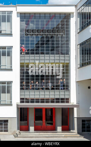 Menschen Besucher den Besuch der Dessauer Bauhaus Gebäude mit Führung. Lehrer Tour Guide erklärt, öffnen Sie das Fenster spezielle System. Stockfoto
