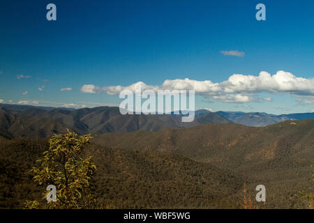 Landschaft geprägt von schroffen bewaldete Gipfel der Berge des alpinen Nationalpark, der zu den entfernten Horizont unter blauem Himmel strecken, Victoria Australien Stockfoto