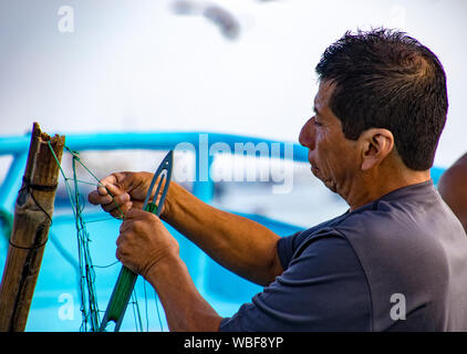 Puerto Lopez, Ecuador - 19.August 2016: Fischer Reparaturen seine Fischernetze in Puerto Lopez, Ecuador Stockfoto