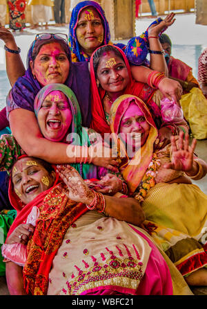 Barsana, Indien - Februar 23, 2018 - Frauen lachen und Schinken für die Kameras, während in der Lack beim Holi Festival abgedeckt Stockfoto