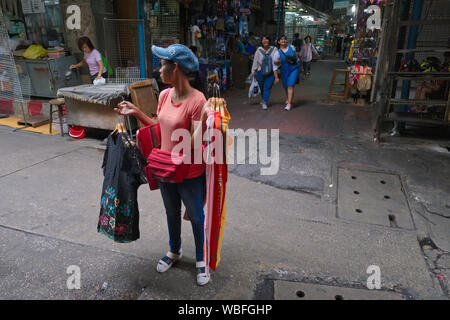 Am frühen Morgen, eine mobile Kleidung Anbieter ist auf der Suche nach Kunden in Sampeng Lane in Chinatown, Bangkok, Thailand Stockfoto