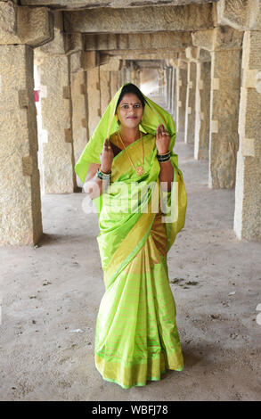 Ein farbenfroh gekleideten indischen Frau in einem alten Tempel in Hampi, Karnataka. Stockfoto