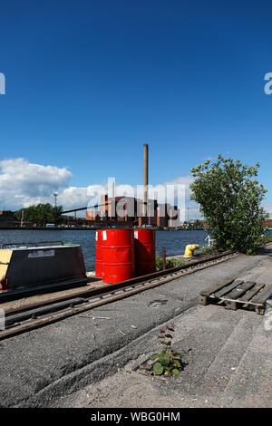 Red Ölfässer in Sompasaari bereits benutzt, Ödland, hanasaari Kraftwerk im Hintergrund, in Helsinki, Finnland Stockfoto
