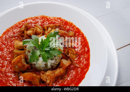 Pikante Gerste Risotto mit Huhn und Tomatensauce auf weißem Hintergrund. Stockfoto