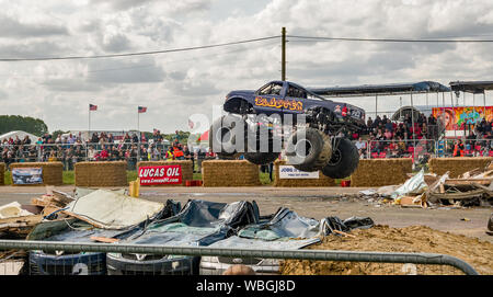 Der Blaster Monster truck Luft getragen, während das Springen über einen Stapel schrott Autos bei einer Demonstration an der Monster Truck Show in Santa Pod ziehen Stockfoto