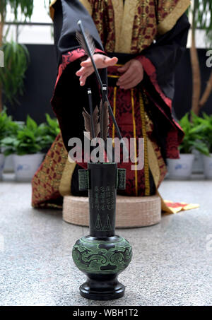 (190827) - ZHENGZHOU, Aug 27, 2019 (Xinhua) - ein Freiwilliger, die traditionelle constume Touhu Spiel spielt, oder Pitch - Topf, einer alten Unterhaltung, dass Spieler erfordert Stöcke von eine festgelegte Strecke in einen Kanister zu werfen, während der Chinesischen Sport Heritage Ausstellung im Museum in Zhengzhou Zhengzhou, Hauptstadt der zentralchinesischen Provinz Henan, Aug 26., 2019. Über 175 Exponate wurden auf dem Display während der Ausstellung, die aus hier Montag trat. (Xinhua/Li an) Stockfoto