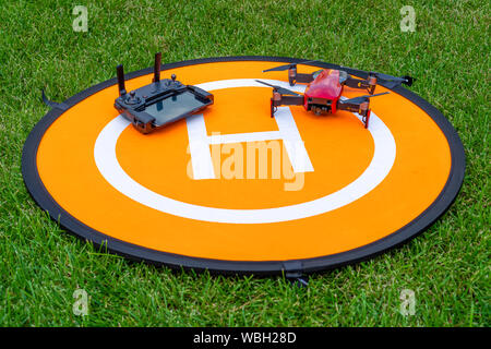 Russland, Tatarstan, 15. Juni 2019. Brummen auf der heliport.Drone Telefon- und Control Panel auf eine orange Hubschrauberlandeplatz auf dem Gras. Stockfoto