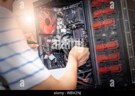 Junger Mann Hand halten Sie den Schraubendreher für den Computer reparieren. Der Ingenieur upgrade Hardware Computer. Stockfoto