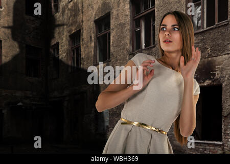 Mädchen durch die Schatten der Mann erschrocken auf Wand der alten, verlassenen Haus in Abend Stockfoto