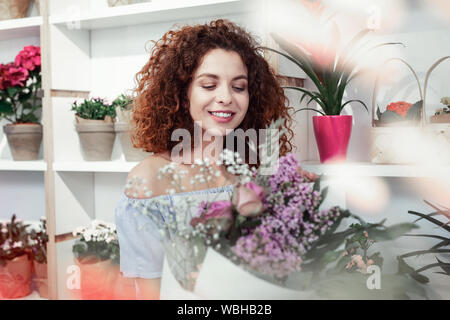 Lächelnd positive rothaarige Frau schön auf bunten Strauß Stockfoto