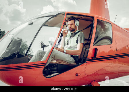 Bärtige pilot tragen Kopfhörer im Gespräch mit seinem Kollegen Stockfoto