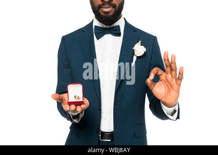 Ansicht der afrikanischen amerikanischen Mann Holding Box mit Hochzeit Ring abgeschnitten und mit Ok Zeichen isoliert auf weißem Stockfoto