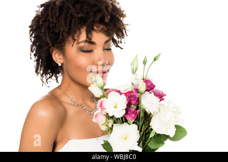 Fröhlich afrikanische amerikanische Braut holding Blumenstrauß während duftende Blumen isoliert auf weißem Stockfoto