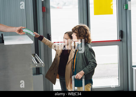 Man Kontrolle Flugtickets von jugendlichen Kinder im Flughafen Stockfoto