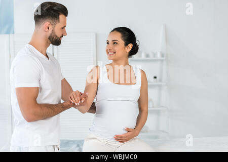 Schöne bärtige Mann stand in der Nähe von Happy schwangere Frau in Spa Stockfoto