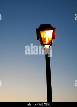 Alte Straßenleuchte leuchtet am frühen Abend. Konzept: Minimalismus. Stockfoto