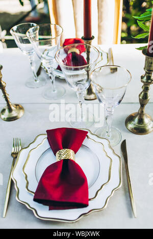 Blick von oben auf ein wunderschön serviert Abendessen mit goldenen Messern, Kerzen und Weingläser. Stockfoto