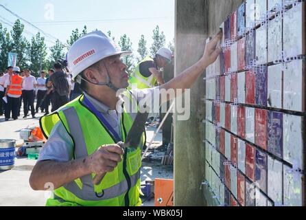 (190827) -- XIONGAN, Aug 27, 2019 (Xinhua) - ein Kandidat Fliesen während einer beruflichen Fähigkeiten Wettbewerb in Xiongan neue Bereich gehalten, im Norden der chinesischen Provinz Hebei, Aug 27., 2019. Dutzende von Mitarbeitern aus Peking, Tianjin und Hebei Provinz Teil in eine berufliche Qualifikation bestreiten, dass hier Dienstag trat, konkurrieren in Fliesen und Schneiden 10-kv-Stromleitungen. (Xinhua / Xing Guangli) Stockfoto