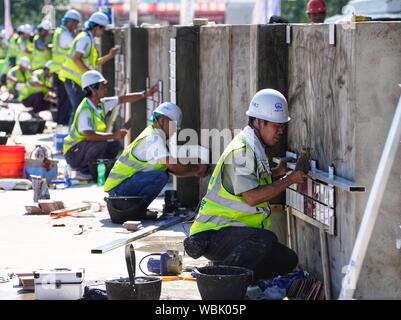 (190827) -- XIONGAN, Aug 27, 2019 (Xinhua) - Kandidaten Kachel während einer beruflichen Fähigkeiten Wettbewerb in Xiongan neue Bereich gehalten, im Norden der chinesischen Provinz Hebei, Aug 27., 2019. Dutzende von Mitarbeitern aus Peking, Tianjin und Hebei Provinz Teil in eine berufliche Qualifikation bestreiten, dass hier Dienstag trat, konkurrieren in Fliesen und Schneiden 10-kv-Stromleitungen. (Xinhua / Xing Guangli) Stockfoto