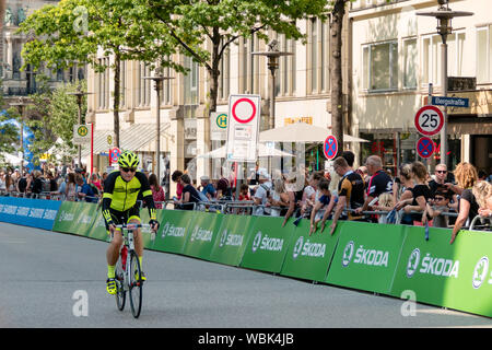 Ein Radfahrer an der 2019 Euroeyes Cyclassics radfahren Wettbewerb in Hamburg, Deutschland, beobachtet von Straße Zuschauer Stockfoto