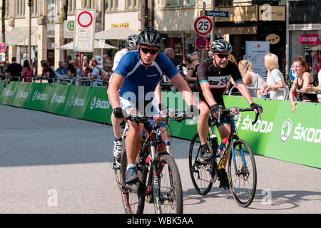 Radfahrer am 2019 Euroeyes Cyclassics Radrennen in Hamburg, Deutschland, beobachtet von Straße Zuschauer Stockfoto