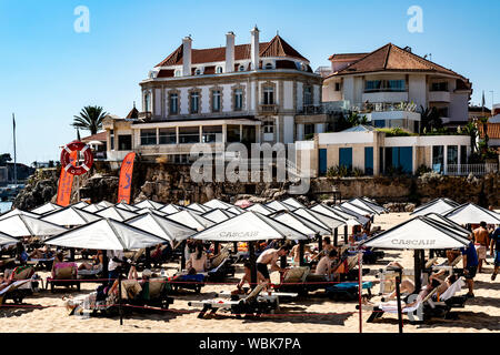 Sonnenschirme und Liegestühle am Strand von Cascais, Portugal. Stockfoto