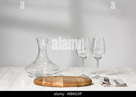 Krug, Wein, Gläser, Besteck und Schneidbrett auf Holz- Oberfläche im Restaurant Stockfoto