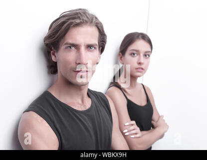 Ernsthafte junge Paar stehen in der Nähe der Wand Stockfoto