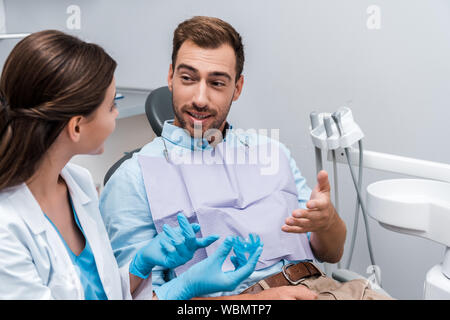 Selektiver Fokus der bärtige Mann deutete in der Nähe von Frau mit Halter in Klinik Stockfoto