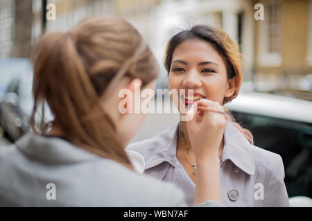 Eine make-up-artist, Make-up auf eine Weibliche asiatische Modell auf der Straße Stockfoto