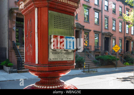 New York Brooklyn Street, Blick auf eine Notrufbox in einer Straße von Residenz-Sandsteingebäuden in Brooklyn Heights, New York City, USA Stockfoto