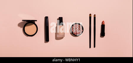 Make-up-Produkte in der Zeile auf rosa Hintergrund Stockfoto