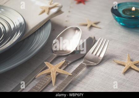 Sommer Tisch mit Serviette und Seesterne Dekoration. Nahaufnahme mit selektiven Fokus. Stockfoto