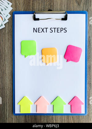 Zwischenablage Text nächsten Schritt auf Holz Schreibtisch. Stockfoto