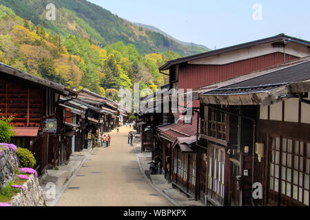 Besucher schlendern Sie entlang der Hauptstraße in Narai, eine Stadt auf der Nakasendo Trail, Kiso Tal in Japan, mit hölzernen Gasthäusern und Geschäften gesäumt Stockfoto