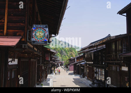 Besucher schlendern Sie entlang der Hauptstraße in Narai, eine Stadt auf der Nakasendo Trail, Kiso Tal in Japan, mit hölzernen Gasthäusern und Geschäften gesäumt Stockfoto