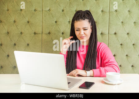 Wenig! Portrait von attraktiven jungen Mädchen mit schwarzen dreadlocks Frisur Sitzen im Cafe, Arbeiten und Videokonferenz auf Laptop, Co Stockfoto