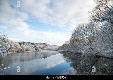 Winterlandschaft in Großbritannien nach Schneefall. Blick auf den britischen See an einem sonnigen Morgen in der Wintersaison mit Schnee auf Bäumen. Stockfoto