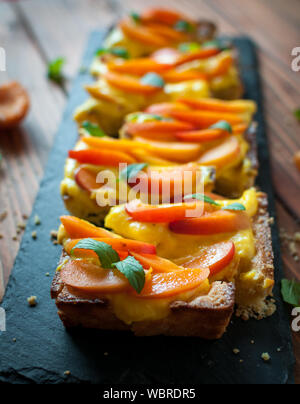 Nahaufnahme der hausgemachte Aprikosen Tarte mit Creme und frischer Minze Stockfoto