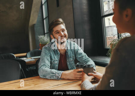 Portrait der kaukasischen Mann und lächelnd zu seiner Kollegin, wie sie in der Cafeteria sitzen. Horizontale erschossen. Selektiver Fokus Stockfoto