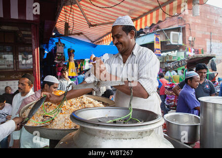 Indien, Delhi, eine muslimische Koch serviert Ihnen eine Portion Reis biryani in der Altstadt von Delhi. Stockfoto