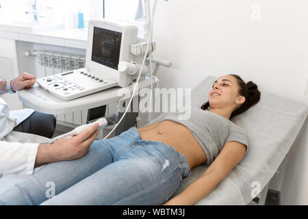 Junge Frau in 4D Ultraschall. Die Ultraschalldiagnostik, die Untersuchung des Abdomens. Stockfoto