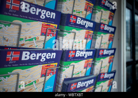 Rack mit Informationen und Karte Broschüren über der norwegischen Stadt Bergen gruss Touristen Aussteigen aus einem Kreuzfahrtschiff in Bergen Hafen angedockt Stockfoto